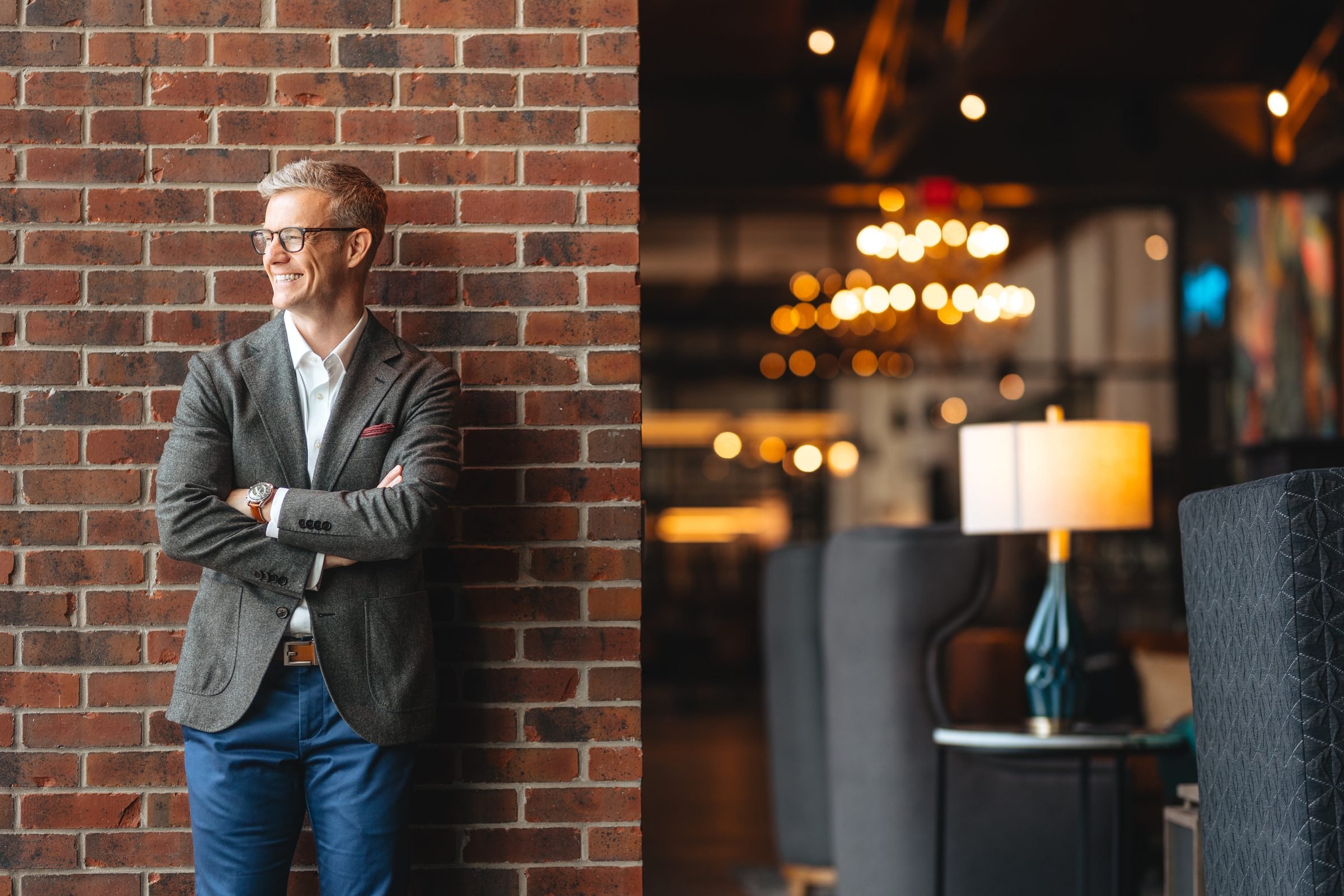 Eric McClerren leaning against a brick wall in a hotel lounge